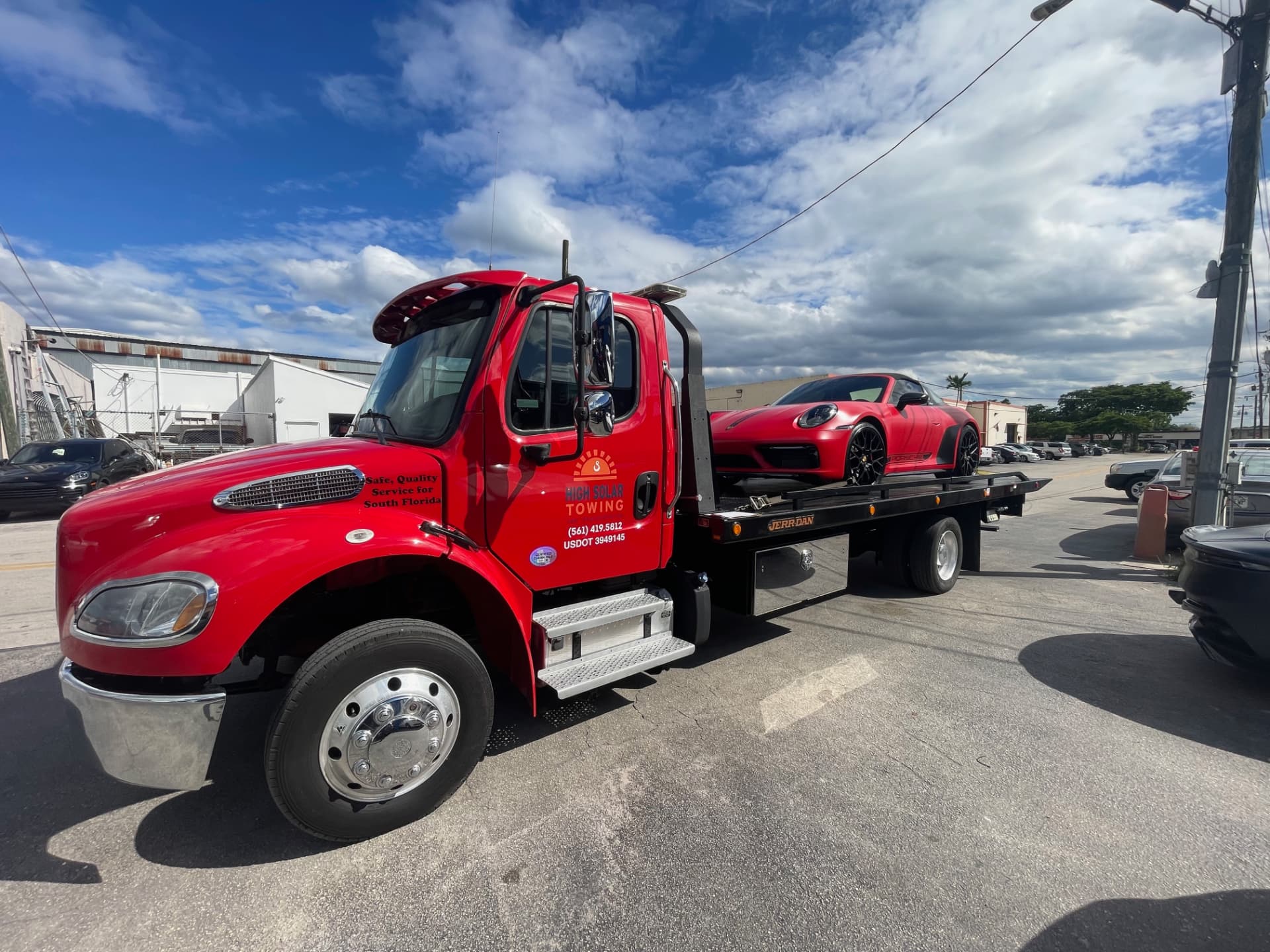 High Solar Towing transporting a red Porsche in Delray Beach